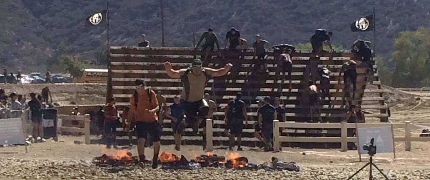 Jumping over the fire at the finish line at the SoCal Spartan Sprint Jumping over the fire at the finish line at the SoCal Spartan Sprint